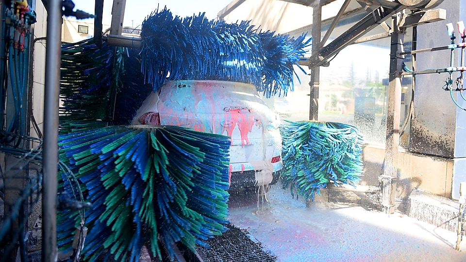 Un automóvil cubierto con espumas de colores en la estación de lavado con rodillo de Lavapro