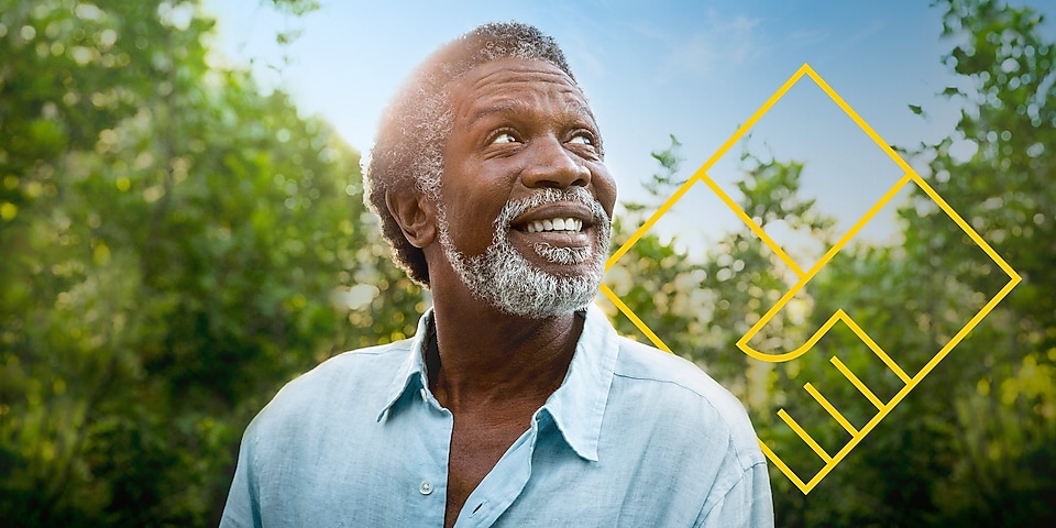Hombre sonriente con barba delante de unos árboles con un resumen del gráfico de generación de valor para el accionista