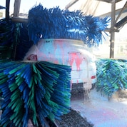 Un automóvil cubierto con espumas de colores en la estación de lavado con rodillo de Lavapro