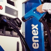 Un cliente retirando el cargador del tótem de carga E-Pro.