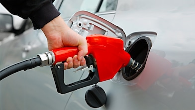 Manguera dispensadora echando combustible al auto