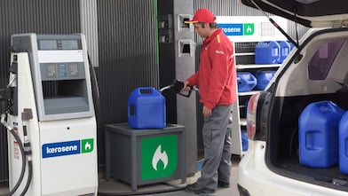 Un atendedor de estación de servicios Shell cargando un bidón con kerosene.