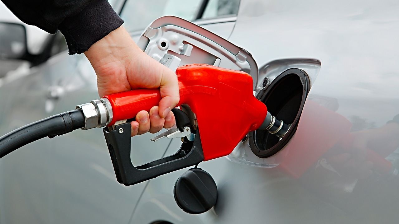 Manguera dispensadora echando combustible al auto