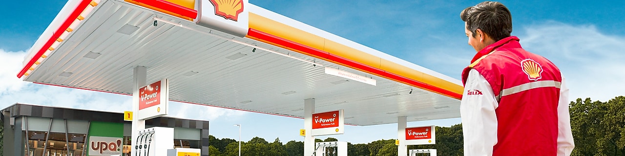 Hombre con chaqueta Shell viendo una estación de servicio
