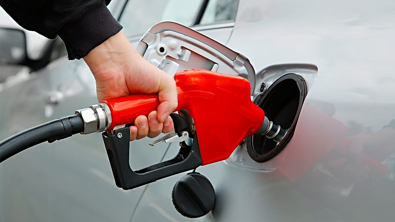 Manguera dispensadora echando combustible al auto