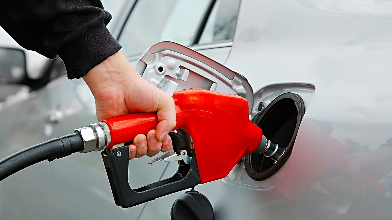 Manguera dispensadora echando combustible al auto