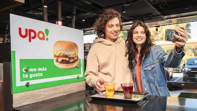 Una pareja de jóvenes se toma una selfie dentro de una tienda de conveniencia upa!